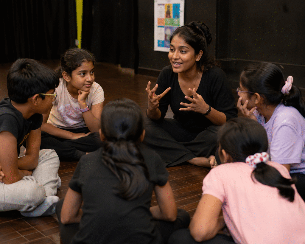 theatre mentor guiding children sitting in a discussion circle during an interactive acting workshop session in jignasa nallagnadla.